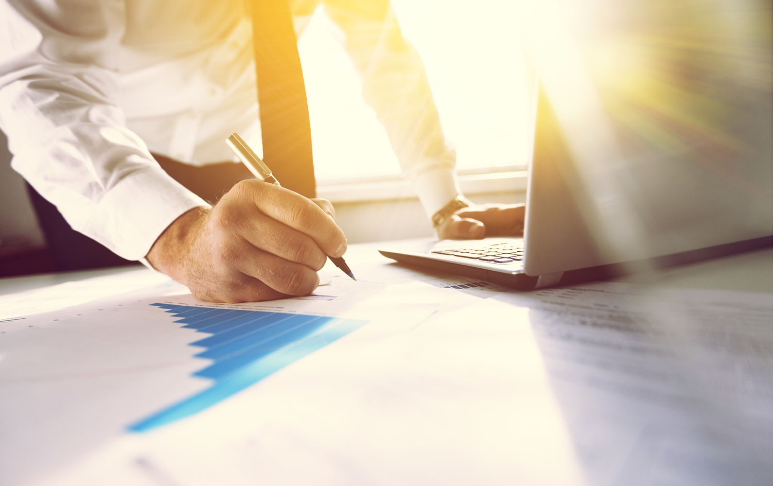 Un bărbat în cravată completează documente